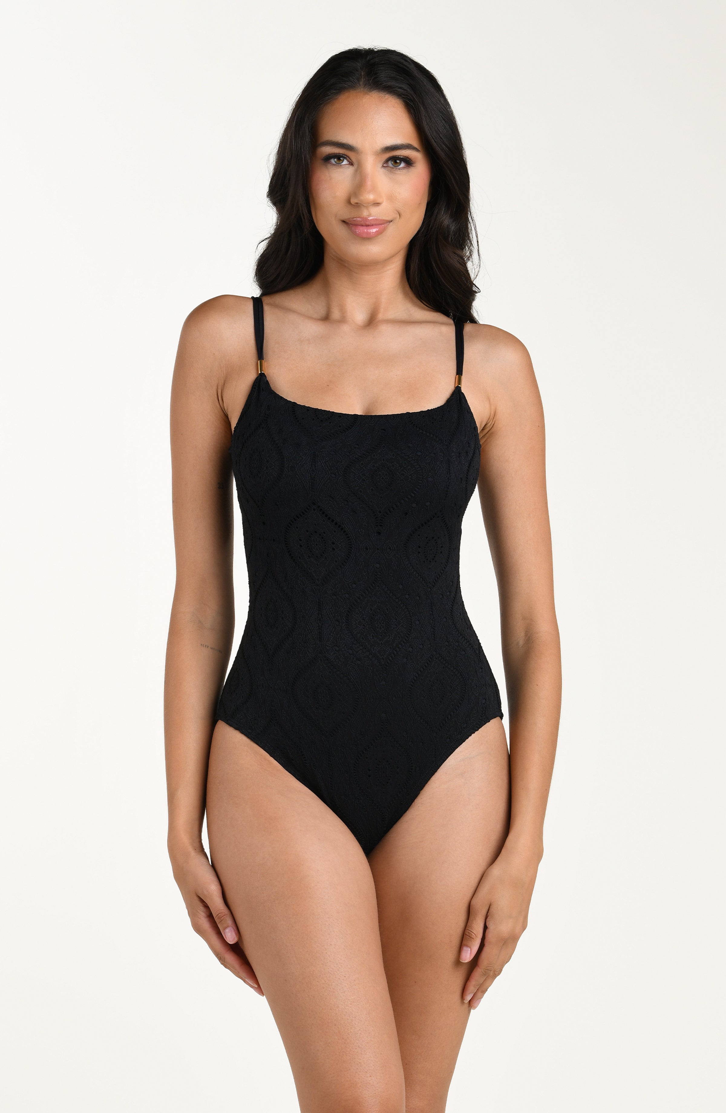 Front image of model wearing a black colored jacquard fabric one piece swimsuit featuring thin over the shoulder straps. 