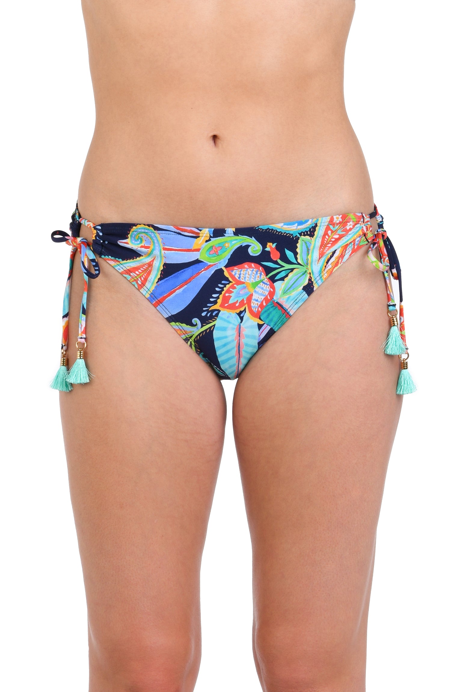 Model is wearing a pink, orange, yellow, and green multicolored tropical patterned side tie hipster bottom against an indigo blue background.