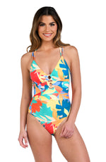 Model is wearing an orange, pink, blue, and aqua multicolored tropical patterned underwire lace front one piece swimsuit.