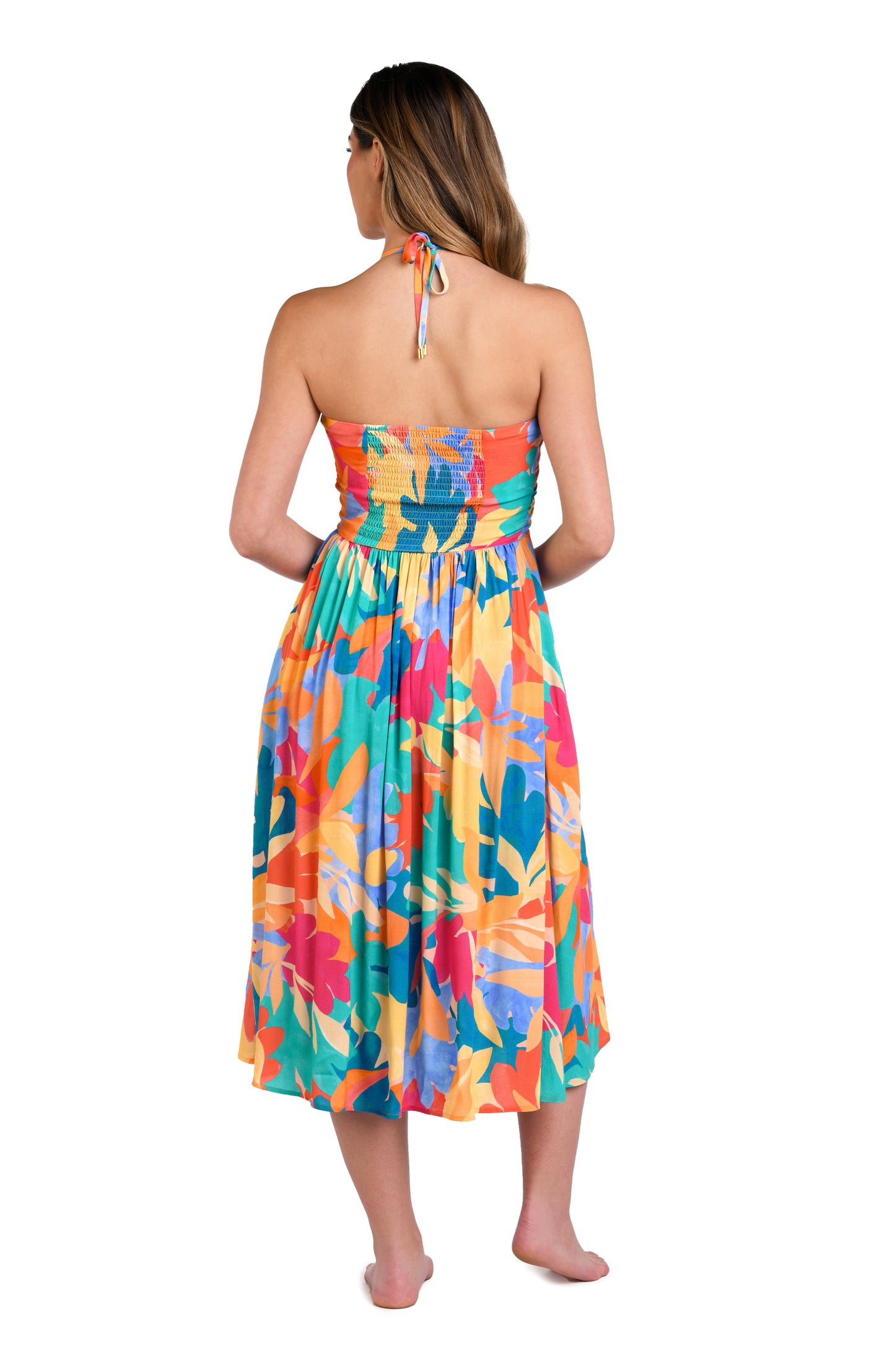 Model is wearing an orange, pink, blue, and aqua multicolored tropical patterned halter midi dress cover up.