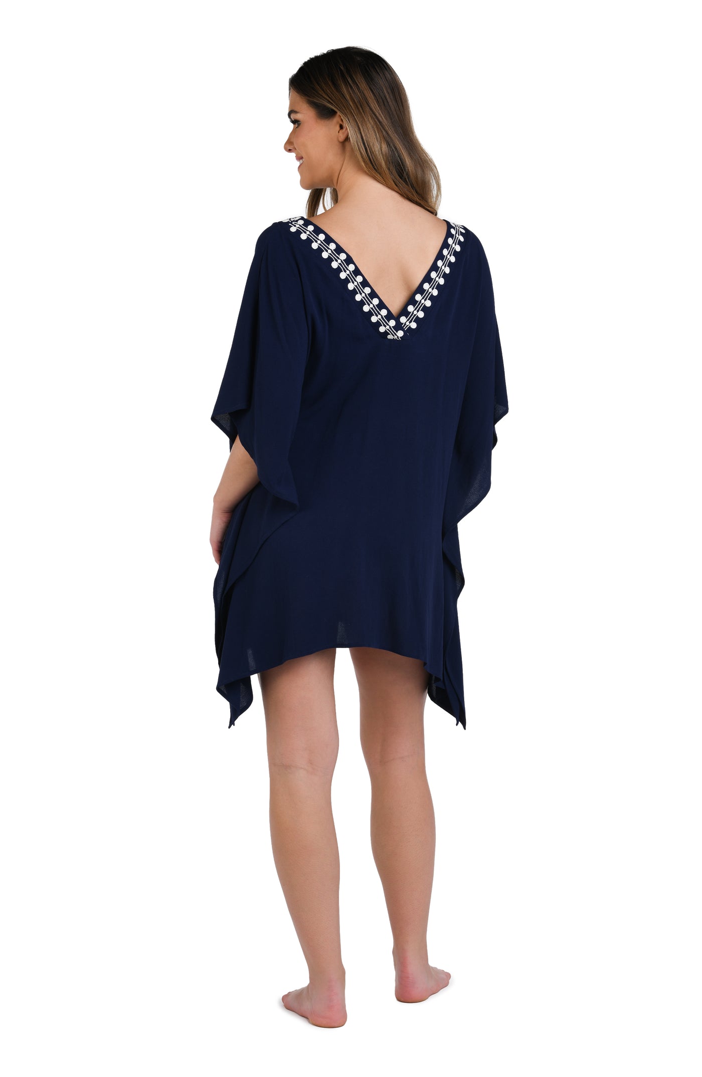 
                  
                    Model is wearing an indigo and white patterned tunic cover up that resembles a string of white sea scallop shells.
                  
                