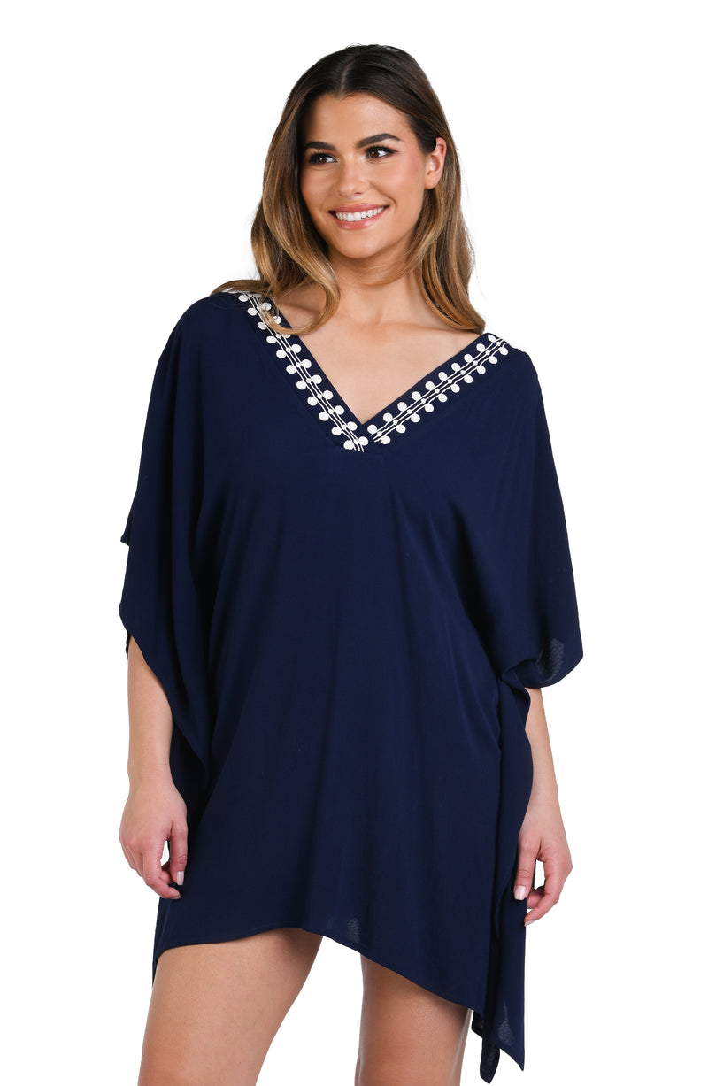 Model is wearing an indigo and white patterned tunic cover up that resembles a string of white sea scallop shells.