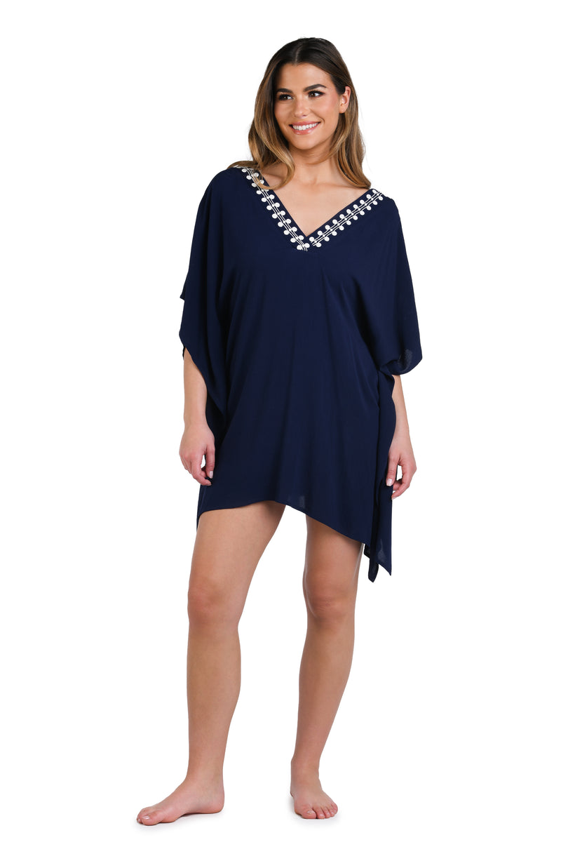 Model is wearing an indigo and white patterned tunic cover up that resembles a string of white sea scallop shells.