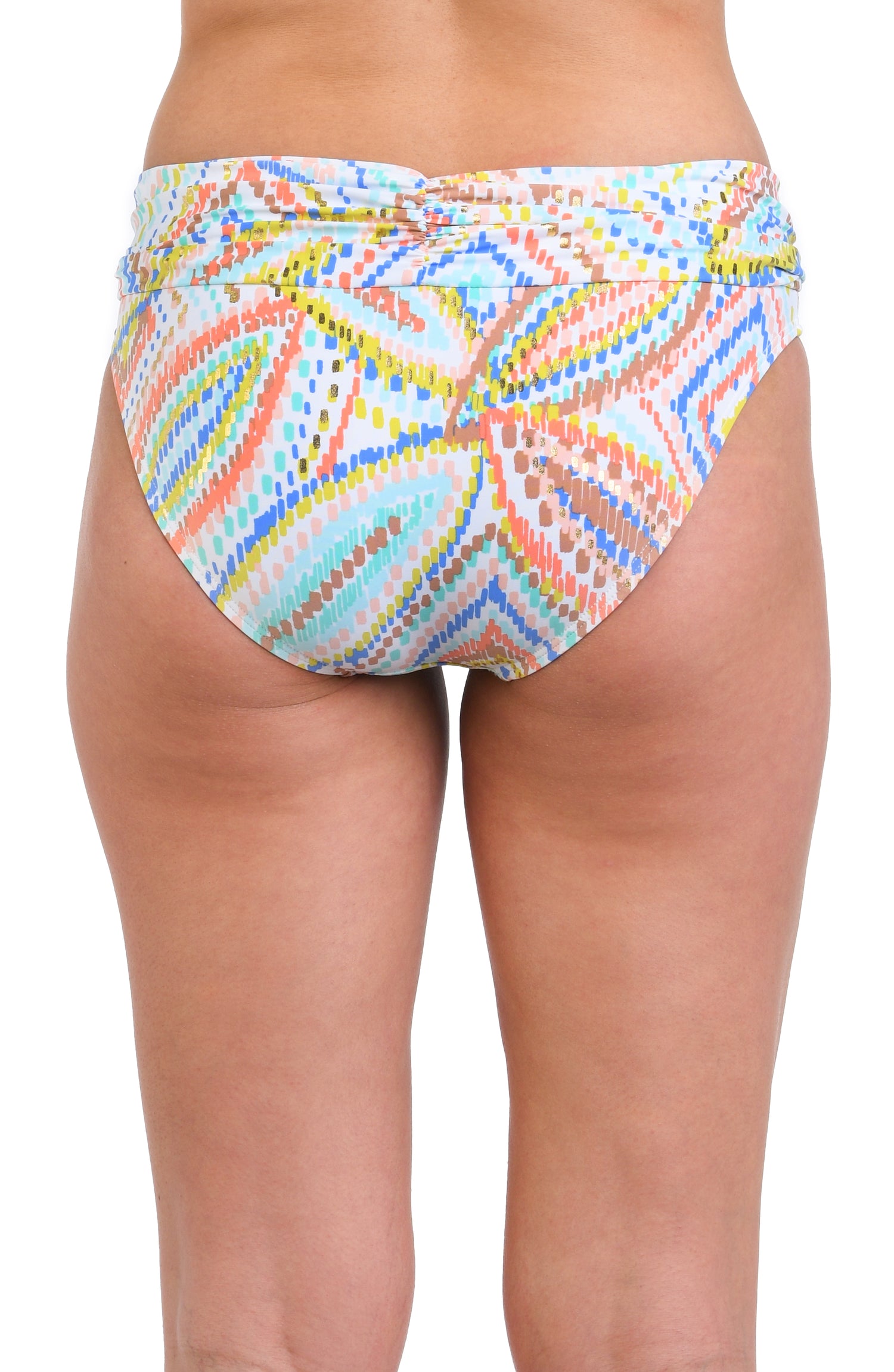 Model is wearing a geometric patterned hipster bikini bottom in pastel shades of pink, blue, and yellow, accented with sporadic glimmers of gold sequin-like details on a white background.