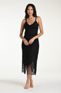 Woman wearing a black fringe midi dress against a white background