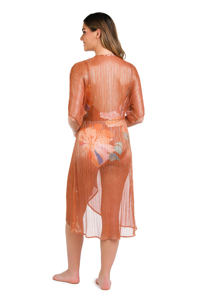 Model is wearing a shimmering orange and pink short sleeve midi dress cover up.