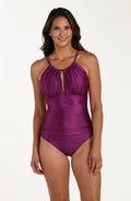 Front image of model wearing a berry colored one-piece swimsuit with a halter neckline, keyhole cutout, and ruched detailing at the waist.