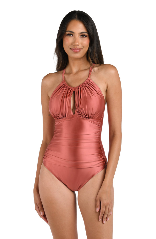 This is a front image of a model  wearing a sienna colored high-neck keyhole one piece with shirring and tummy control from the Earth Goddess swim collection.