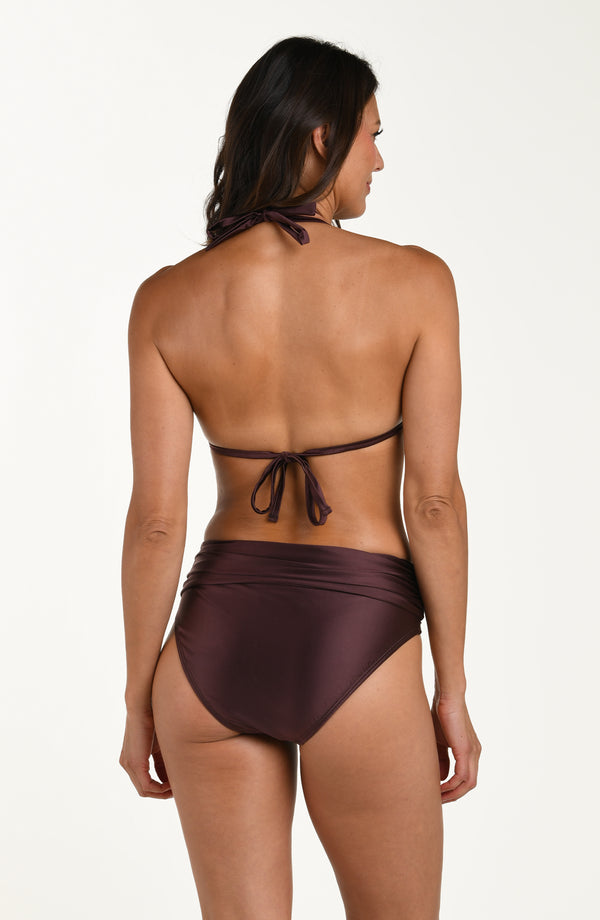 Full body back image of model wearing a halter bikini top in a truffle (brown) color with ruched triangle cups and adjustable back ties. This is paired with matching bikini bottoms. 