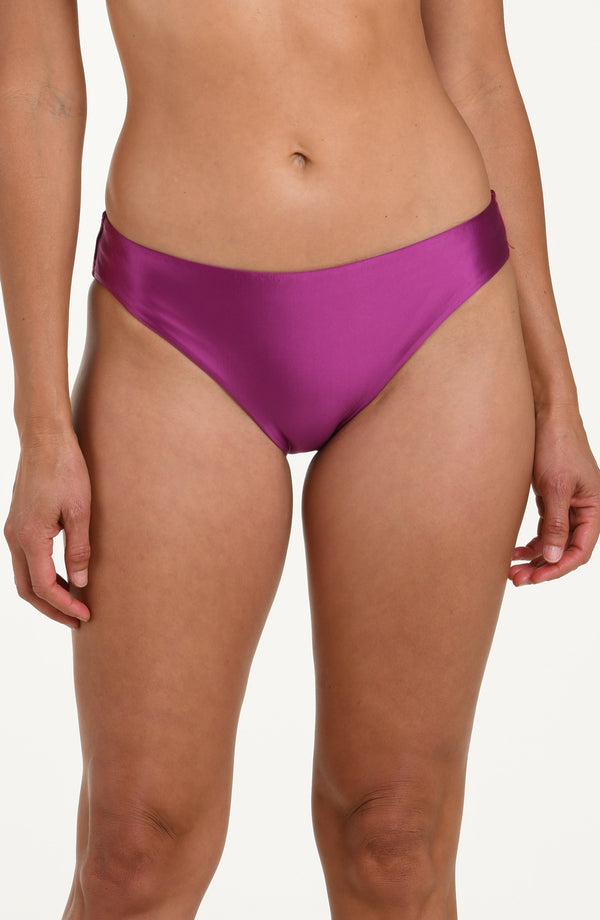 Front image of model wearing basic hipster bikini bottoms in a berry color. 