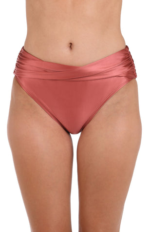 This is the front image of a model wearing a sienna colored twist front high-waisted swimsuit bottom from the Earth Goddess swim collection.