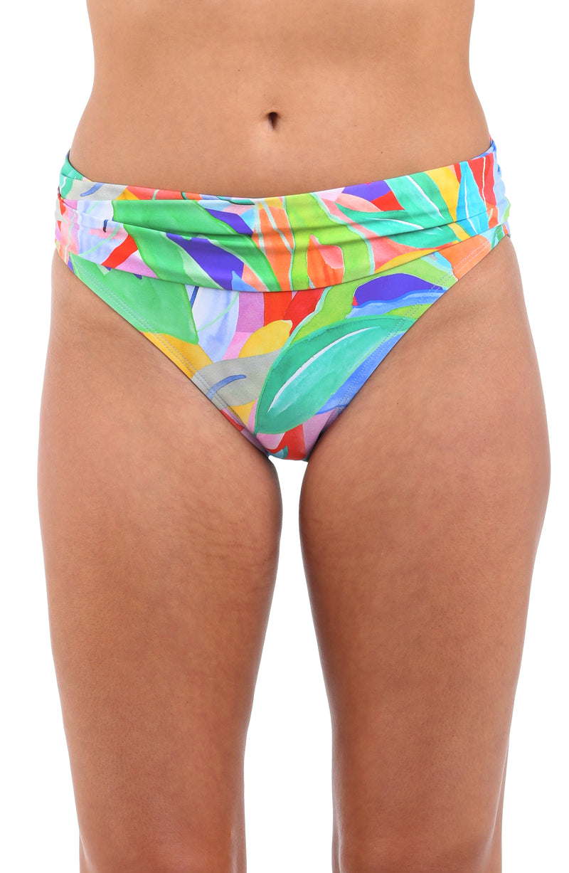 Front image of model wearing the Tropi-flage Shirred Band Hipster Bottom in a bright multi colored tropical print.