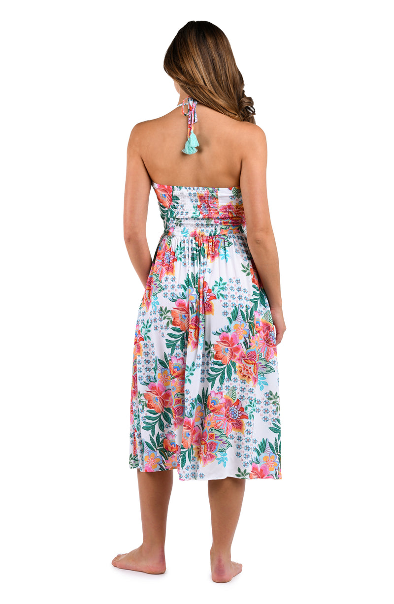 Back image of model wearing the Riviera Resort Halter Midi Dress Cover Up in a white multi colored tropical print.