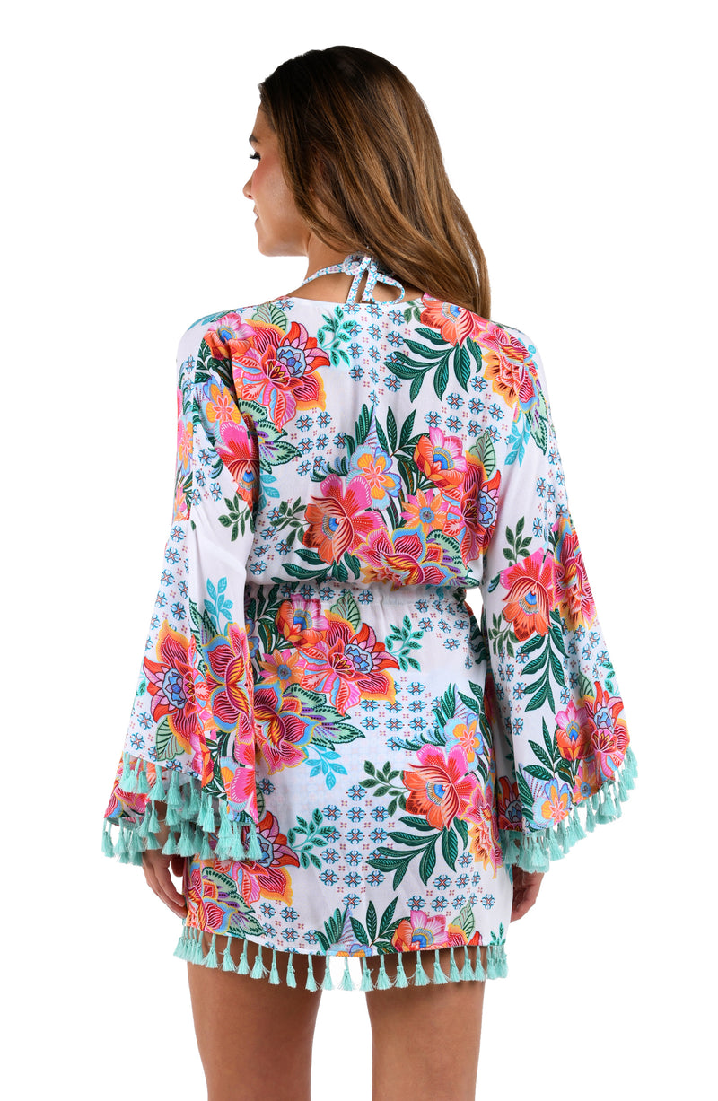 Back image of model wearing the Riviera Resort Kimono Cover Up in a white multi colored tropical print.