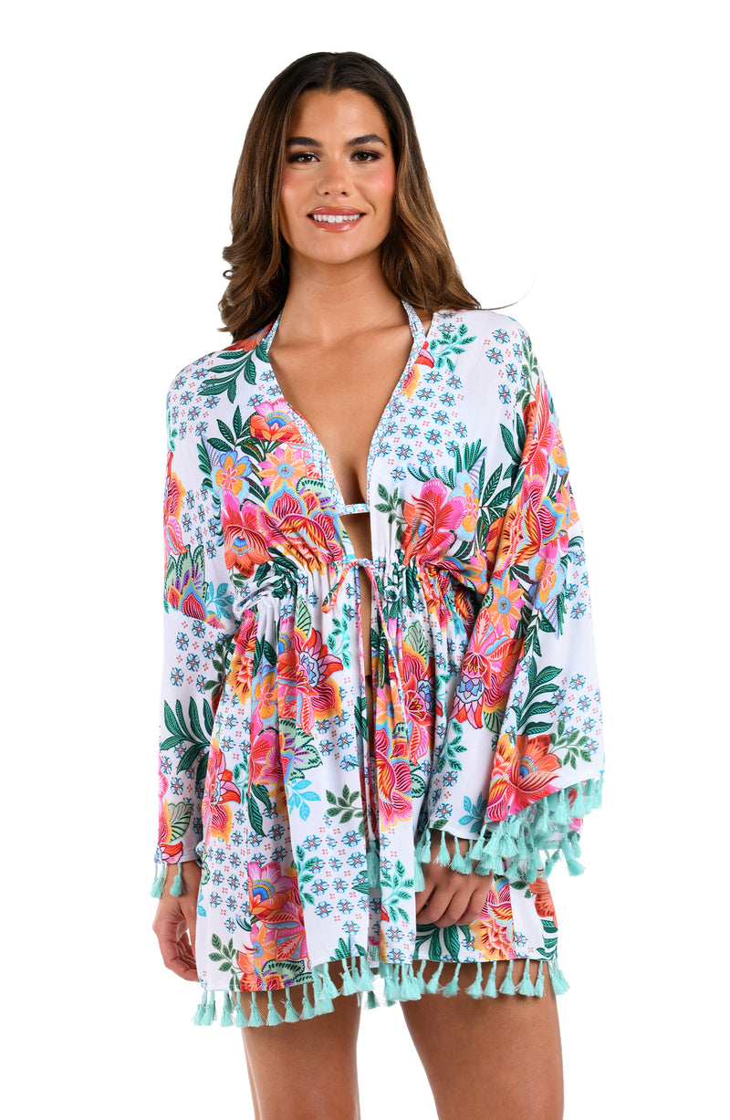 Front image of model wearing the Riviera Resort Kimono Cover Up in a white multi colored tropical print.