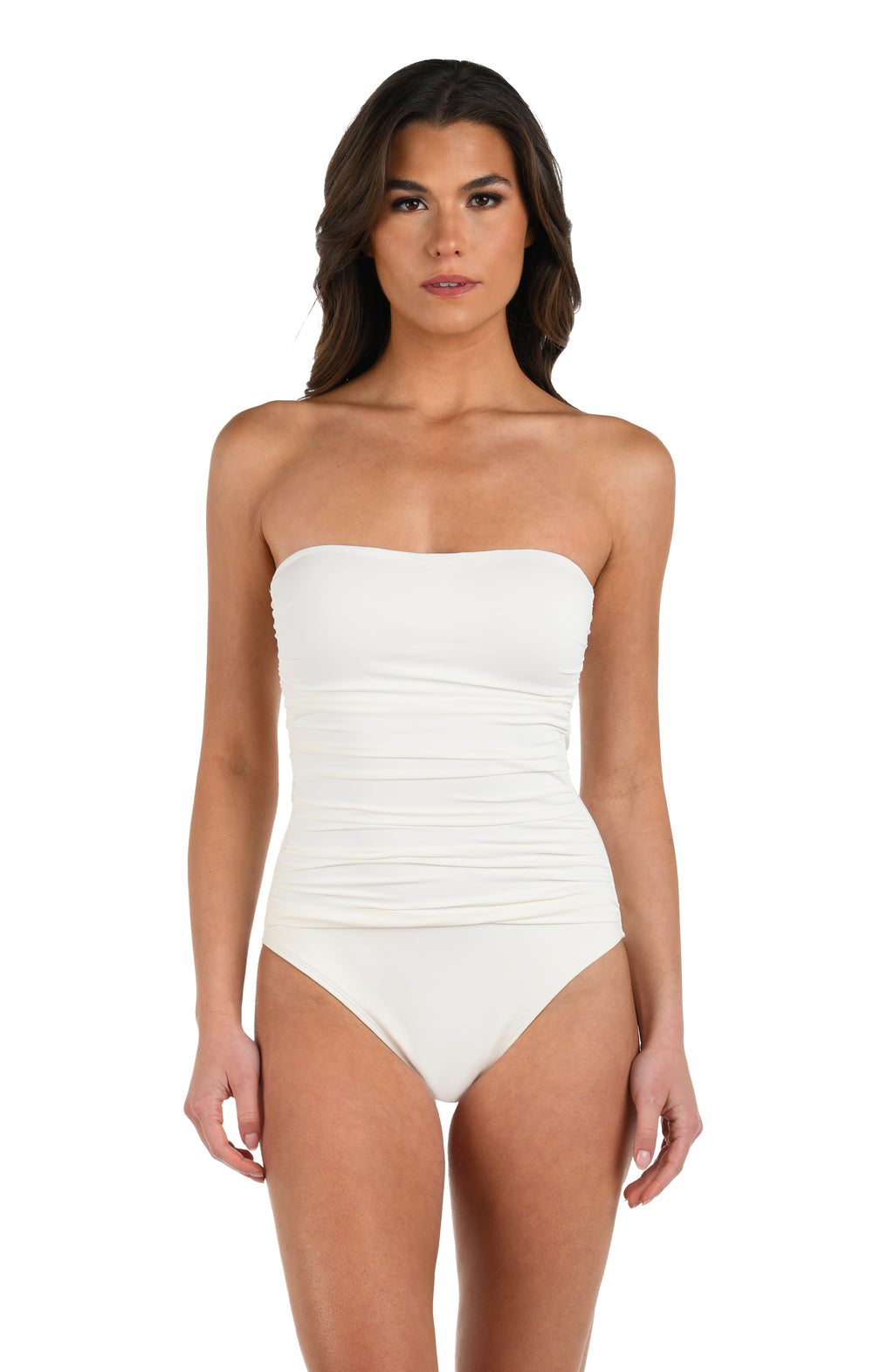 Front image of model wearing an ivory colored one-piece swimsuit featuring a shirred body and no shoulder straps to reveal a bandeau look.