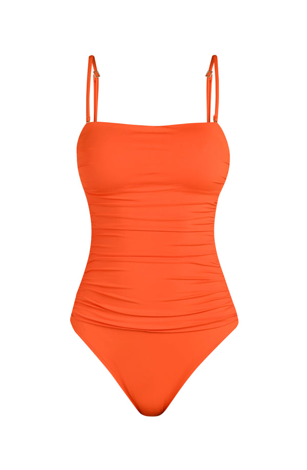 Floating image of a solid tangelo (orange) colored one-piece swimsuit with removable thin shoulder straps, a straight neckline, and ruched detailing at the waist.