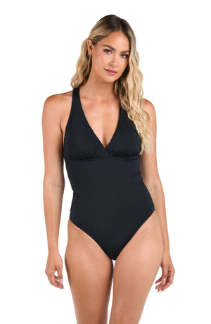 Model is wearing the Island Goddess Macrame Back One Piece in Black.