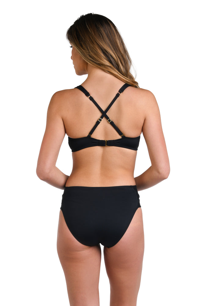 Model is wearing a solid black colored over-the-shoulder bikini swimsuit top.