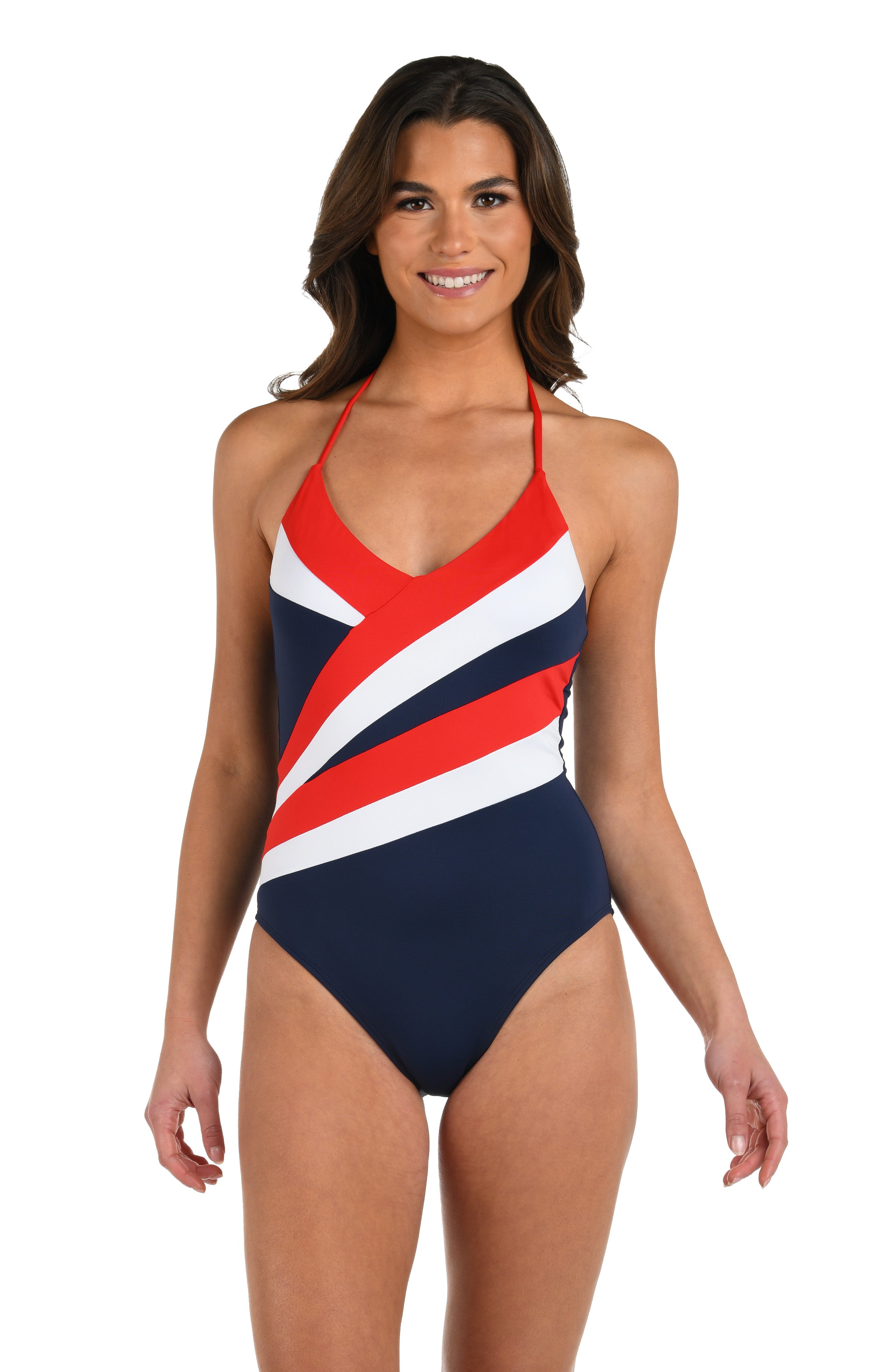 Model wearing a one piece swimsuit featuring a plunging neckline and bold diagonal color-block stripes in red, white, and indigo blue.