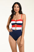 Woman wearing a red, white, and blue striped one piece swimsuit against a beige background