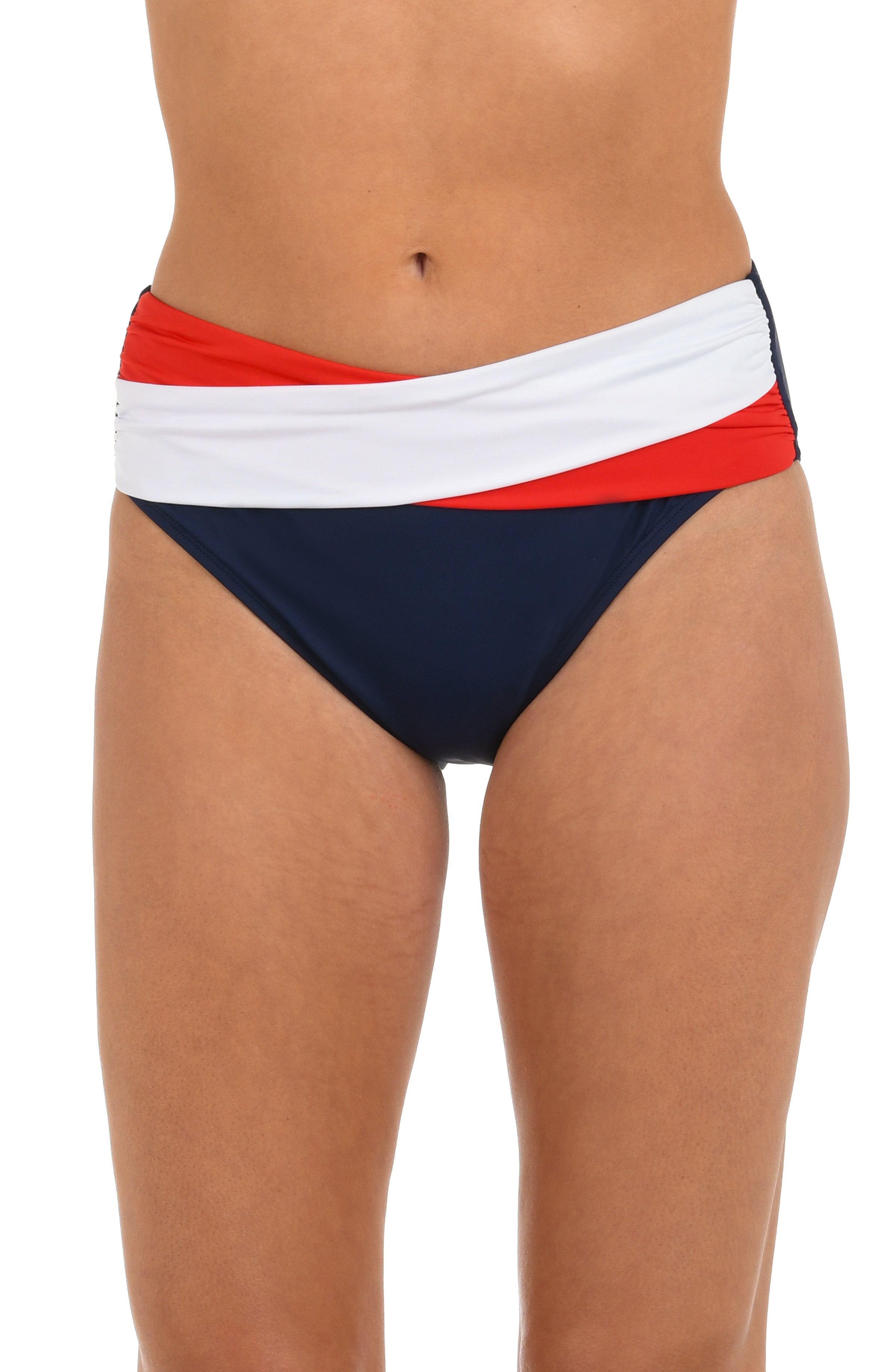 Image of model wearing a red, white, and blue color block mid-waist bikini bottom featuring a crossover front and moderate rear coverage.