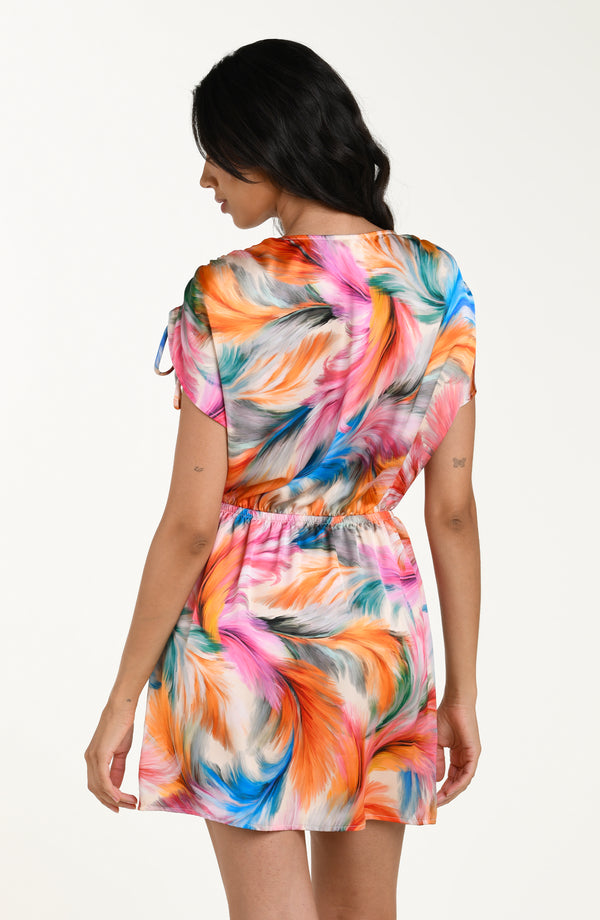 Back image of model wearing a multicolored feather printed short cover-up dress featuring a V-neckline, cinched waist, and adjustable drawstring sleeves, and pockets.