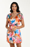Front image of model wearing a multicolored feather printed short cover-up dress featuring a V-neckline, cinched waist, and adjustable drawstring sleeves, and pockets.