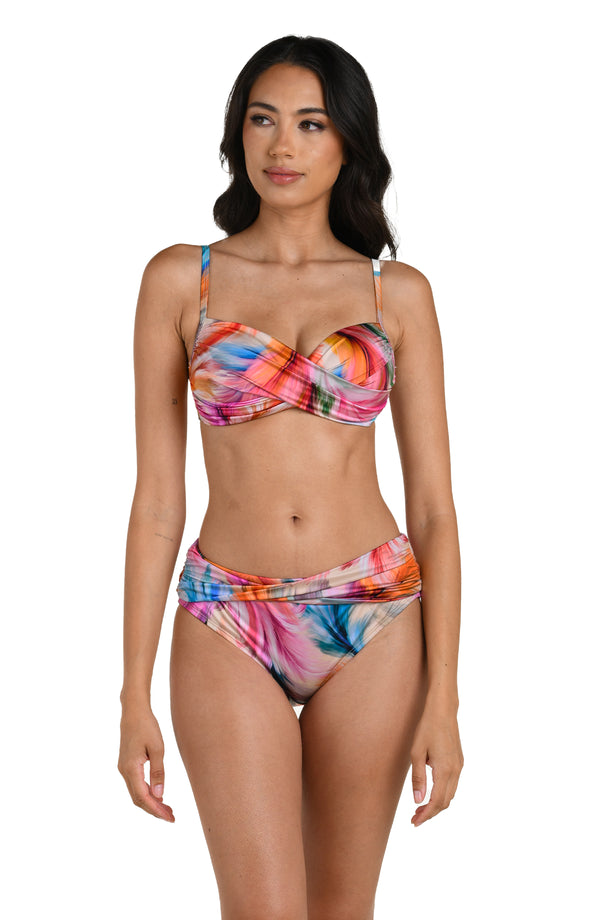 Front image of model wearing a multicolored feather printed bikini top with adjustable thin straps and a wrap-style front. This is paired with matching bikini bottoms.