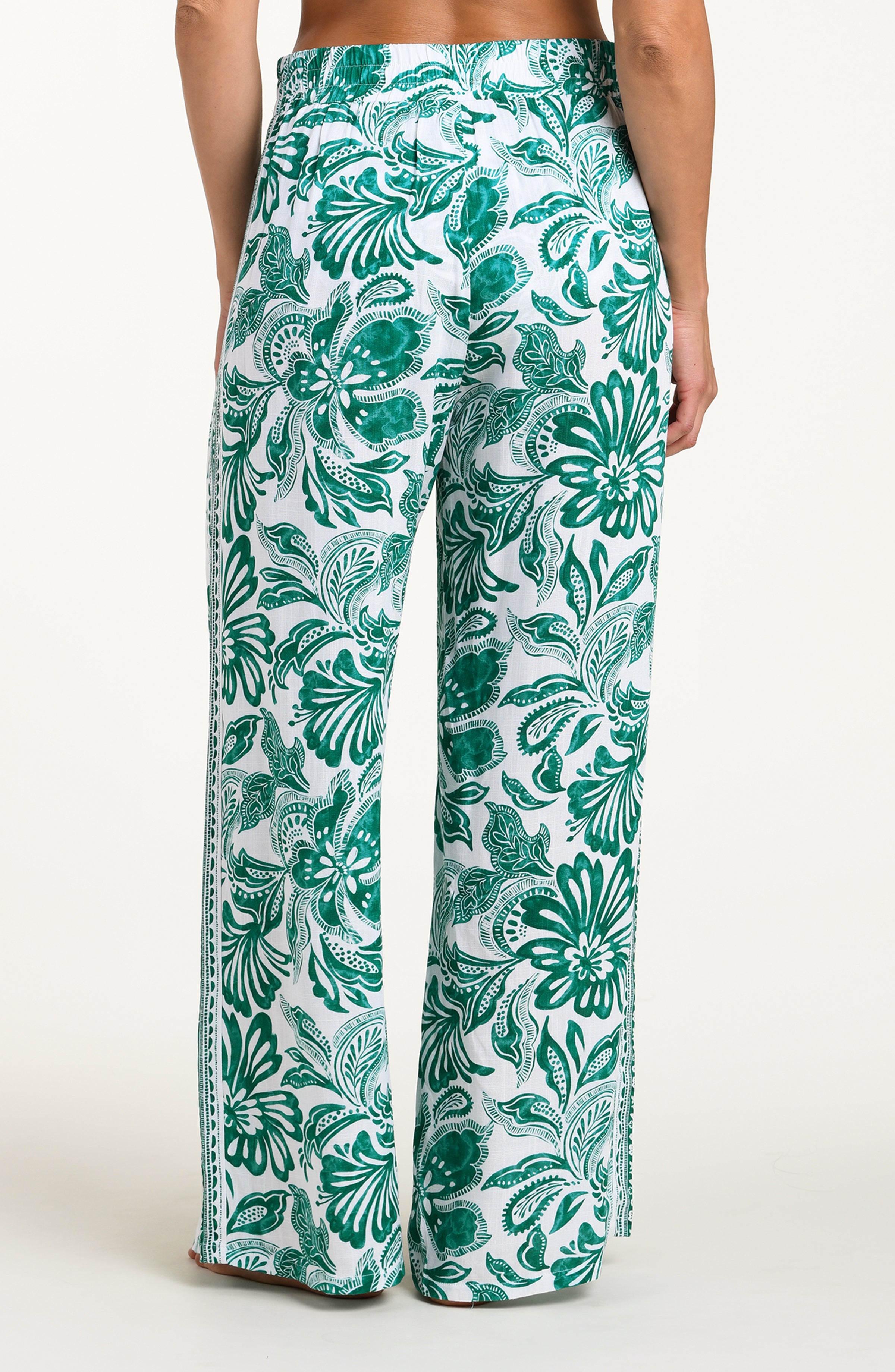 Green and white floral-patterned pants on a white background
