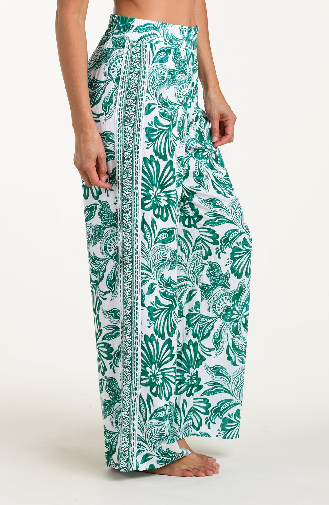 
                  
                    Green and white floral-patterned pants on a white background
                  
                