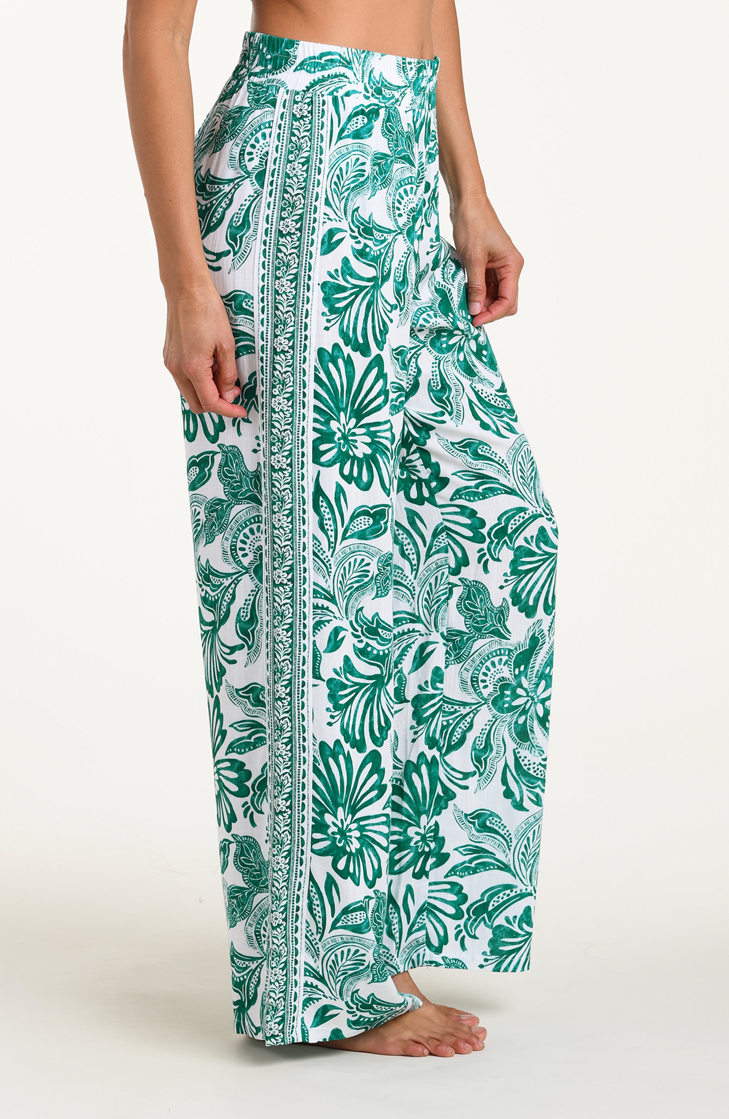 Green and white floral-patterned pants on a white background