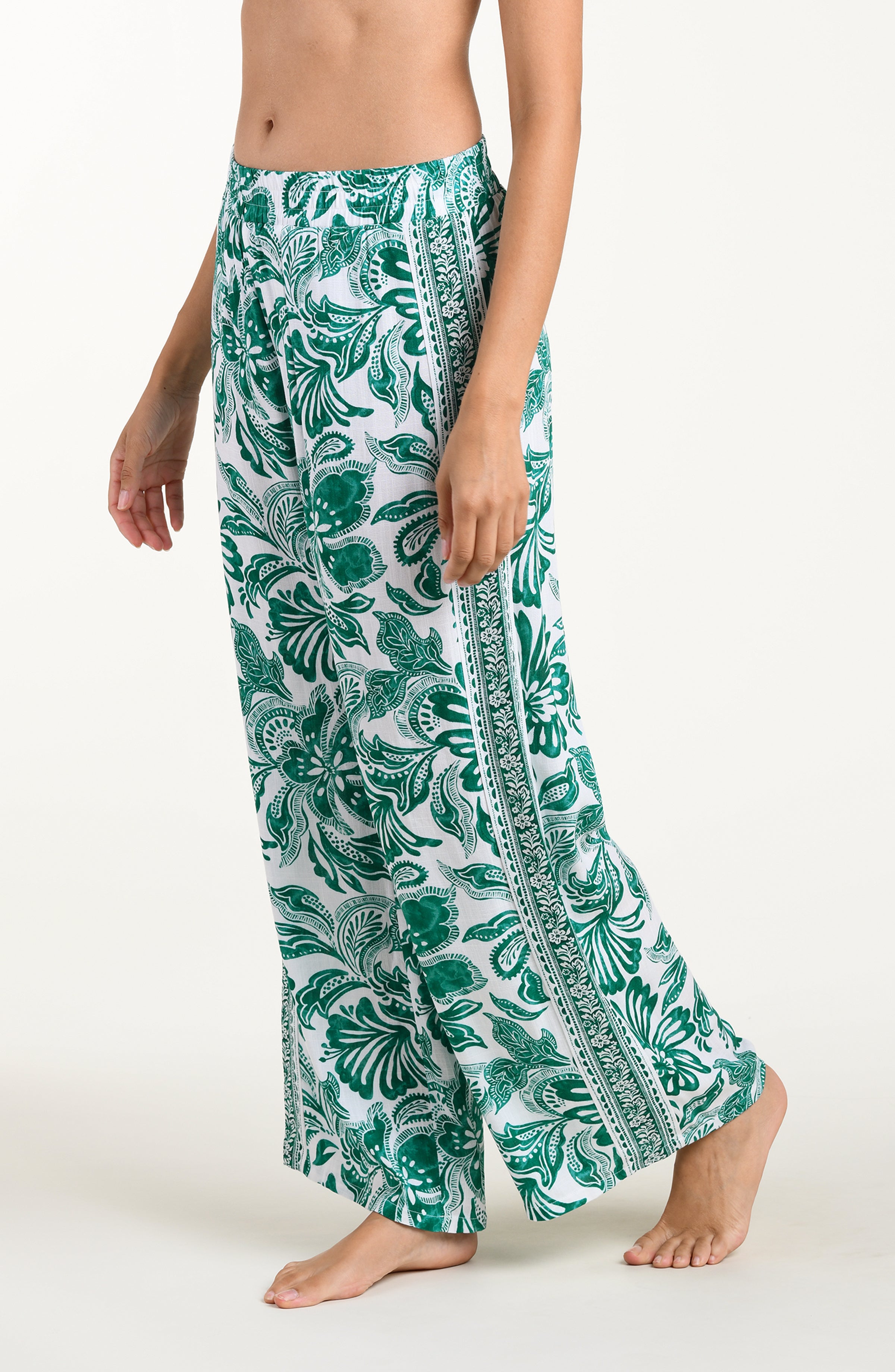 Green and white floral-patterned pants on a white background