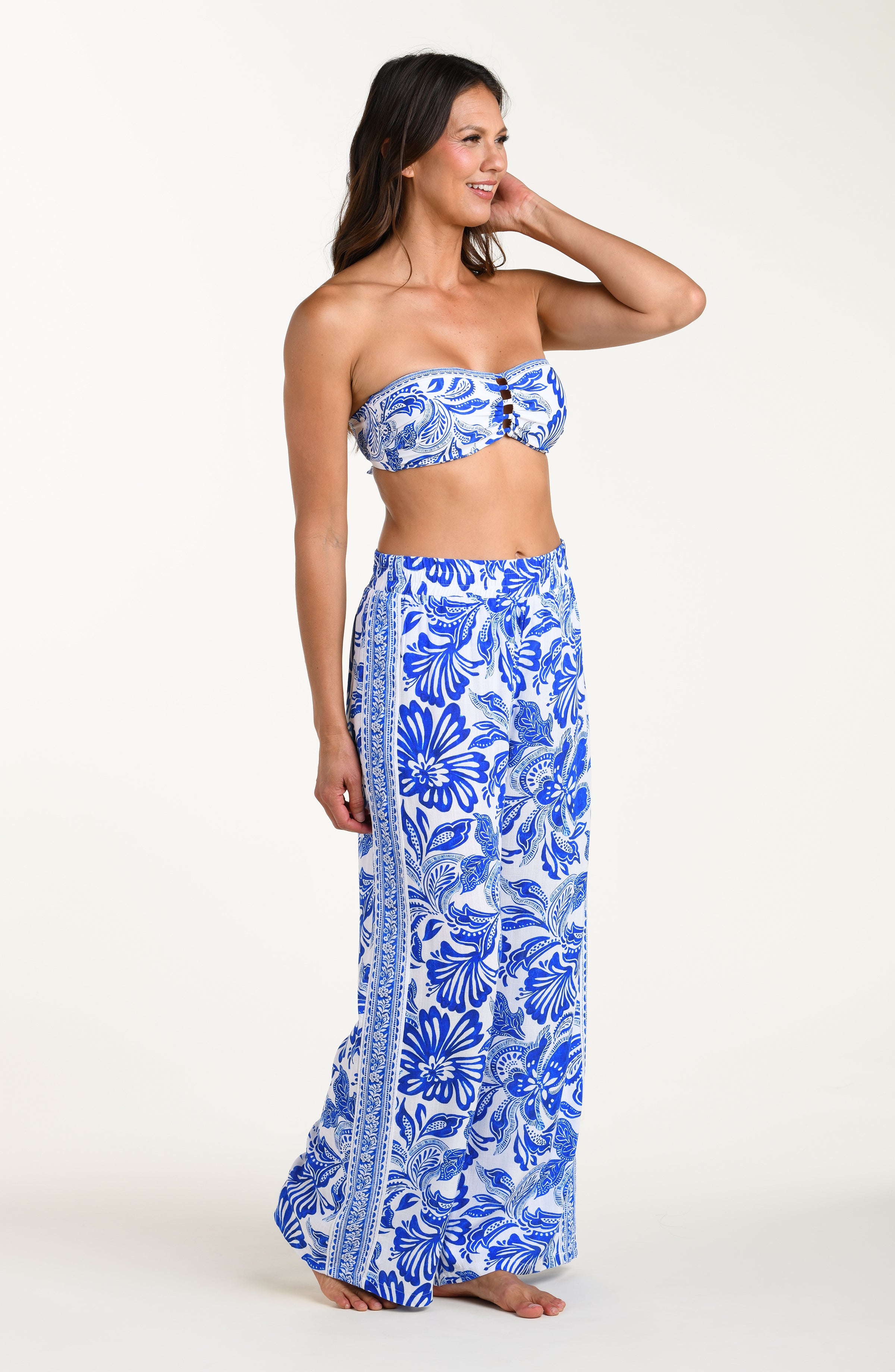 Woman wearing a blue floral strapless top and long skirt on a white background