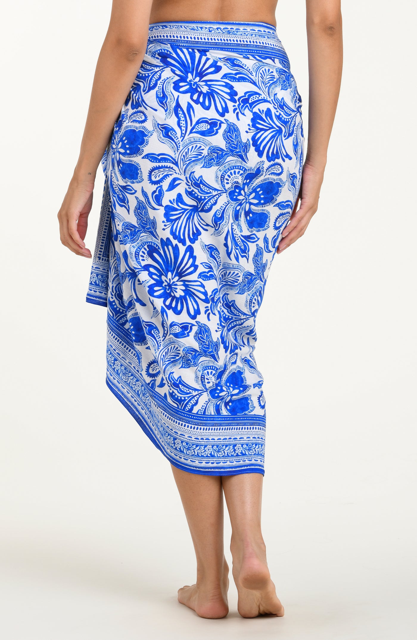 
                  
                    Woman wearing a blue floral patterned sarong on a white background
                  
                