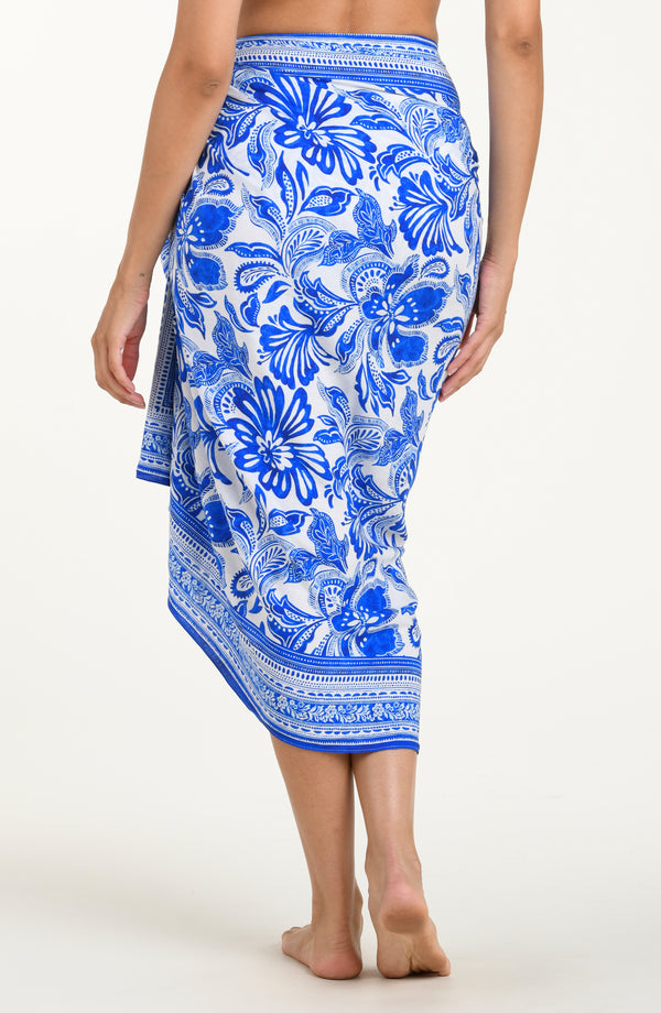 Woman wearing a blue floral patterned sarong on a white background