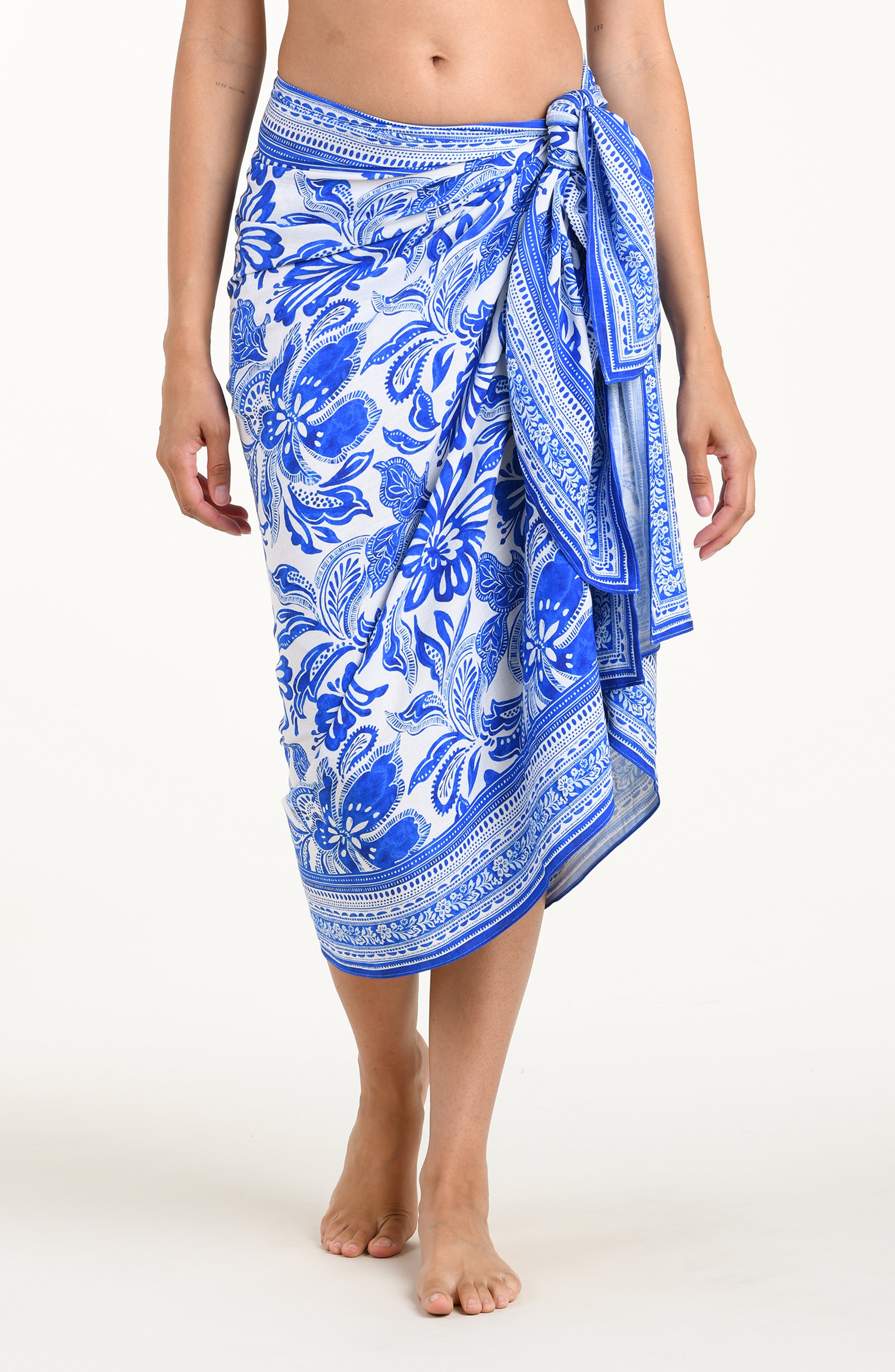 Blue and white patterned sarong on a person against a white background