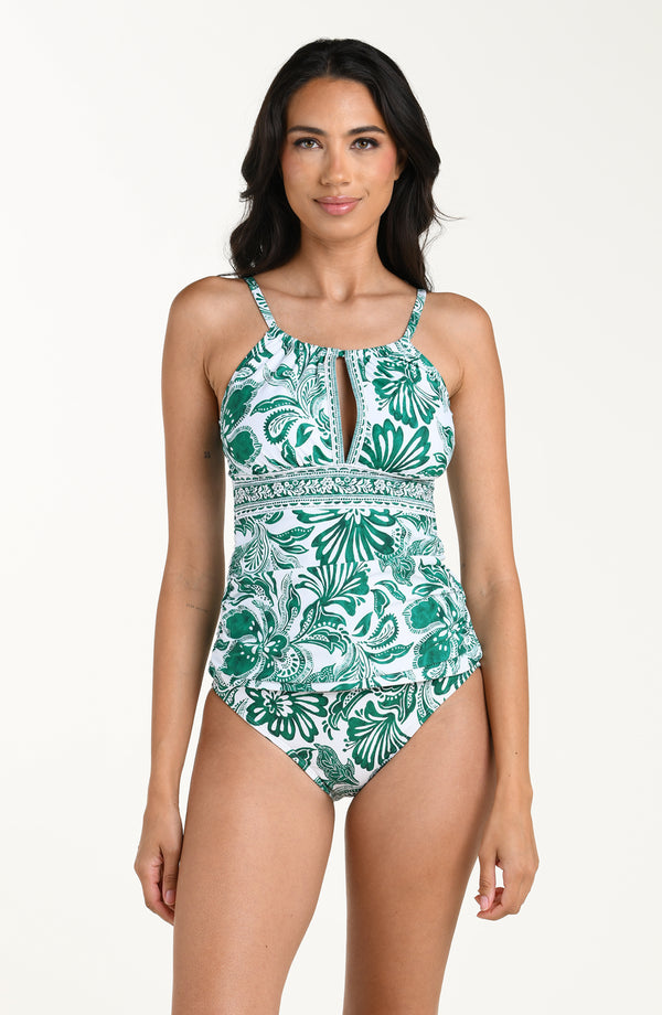 Woman wearing a green and white floral tankini top and matching bottom on a white background
