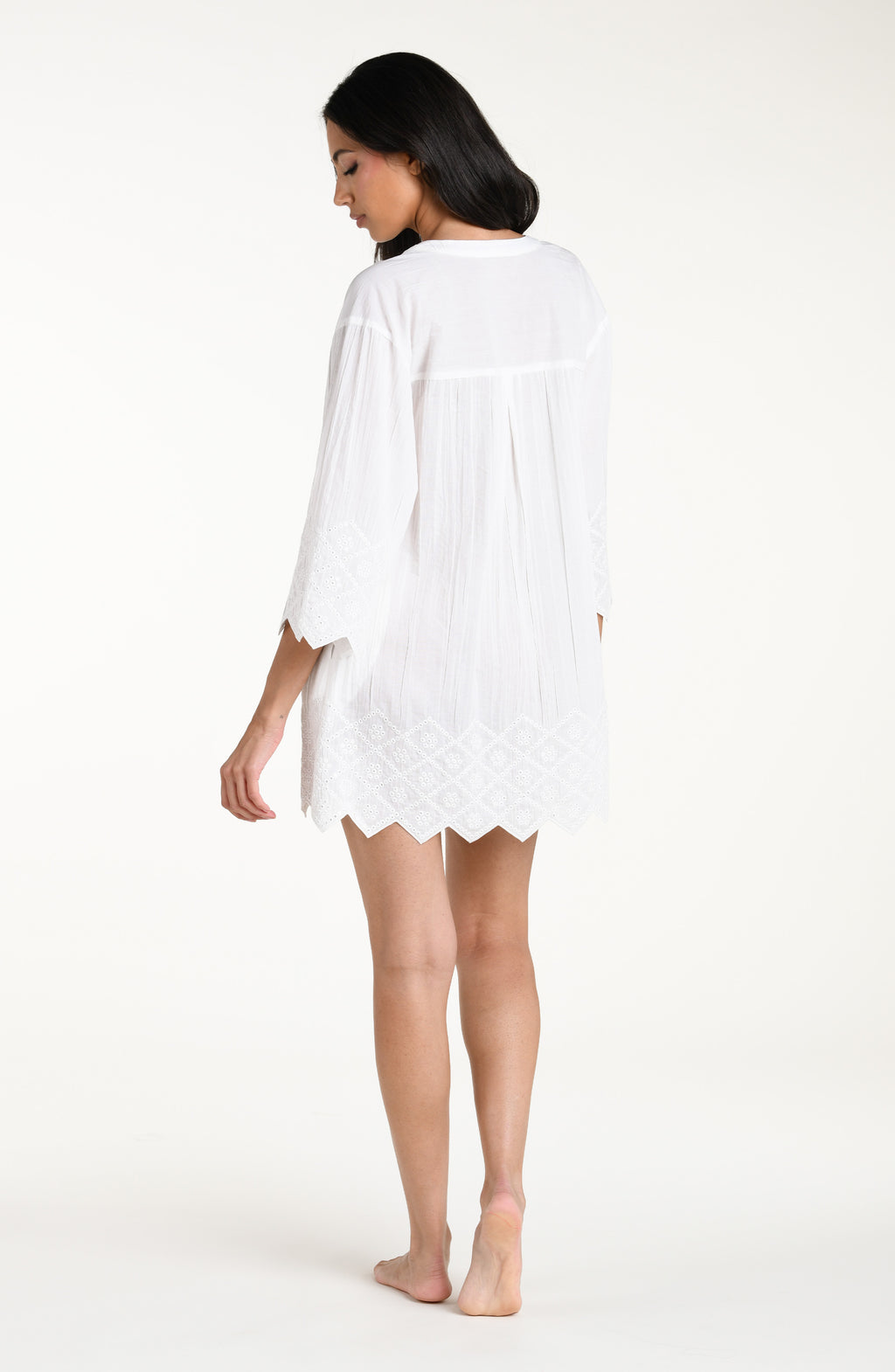 Woman wearing a white V-neck tunic against a white background