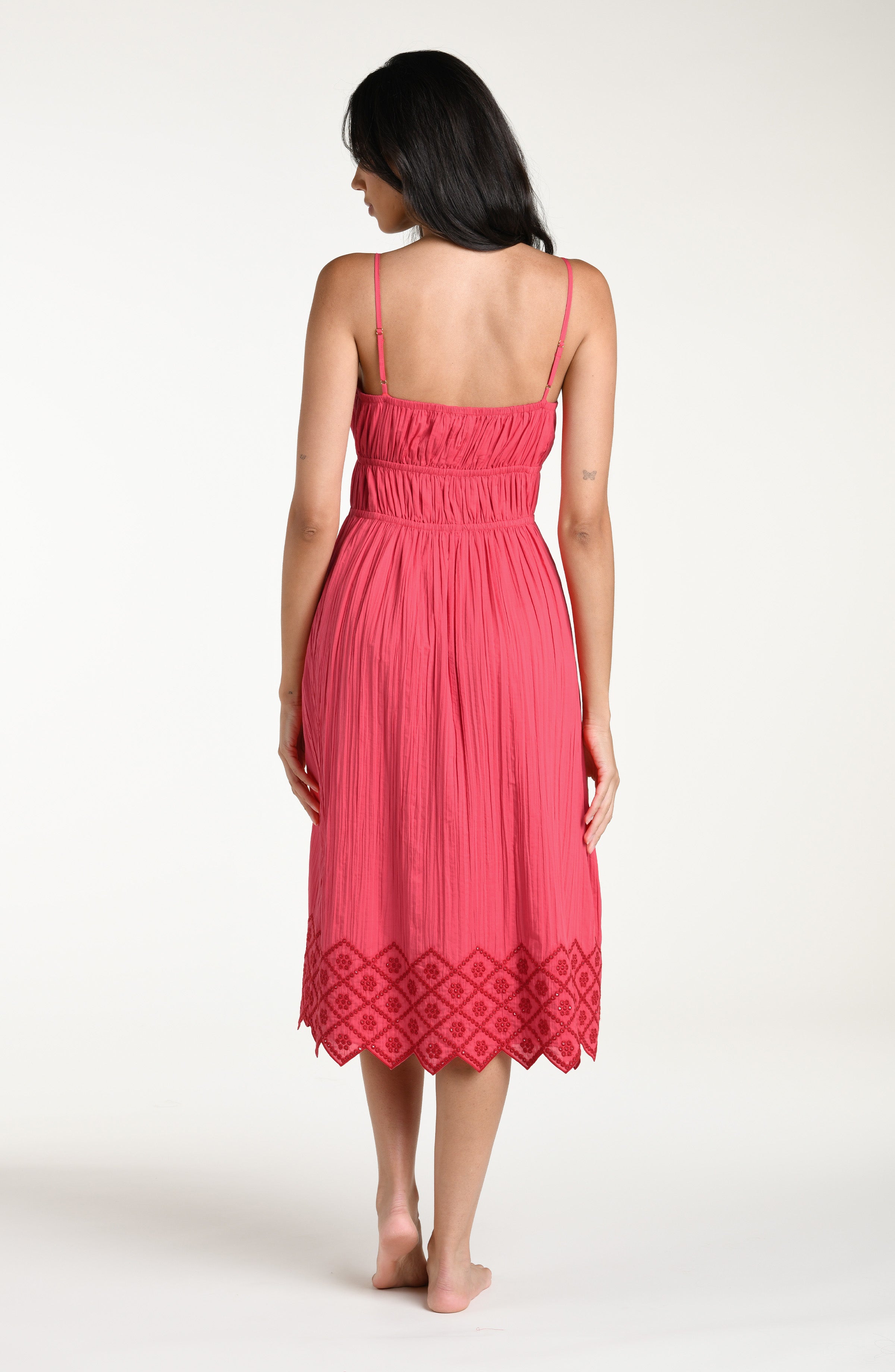 Woman wearing a guava colored midi cover up dress against a white background