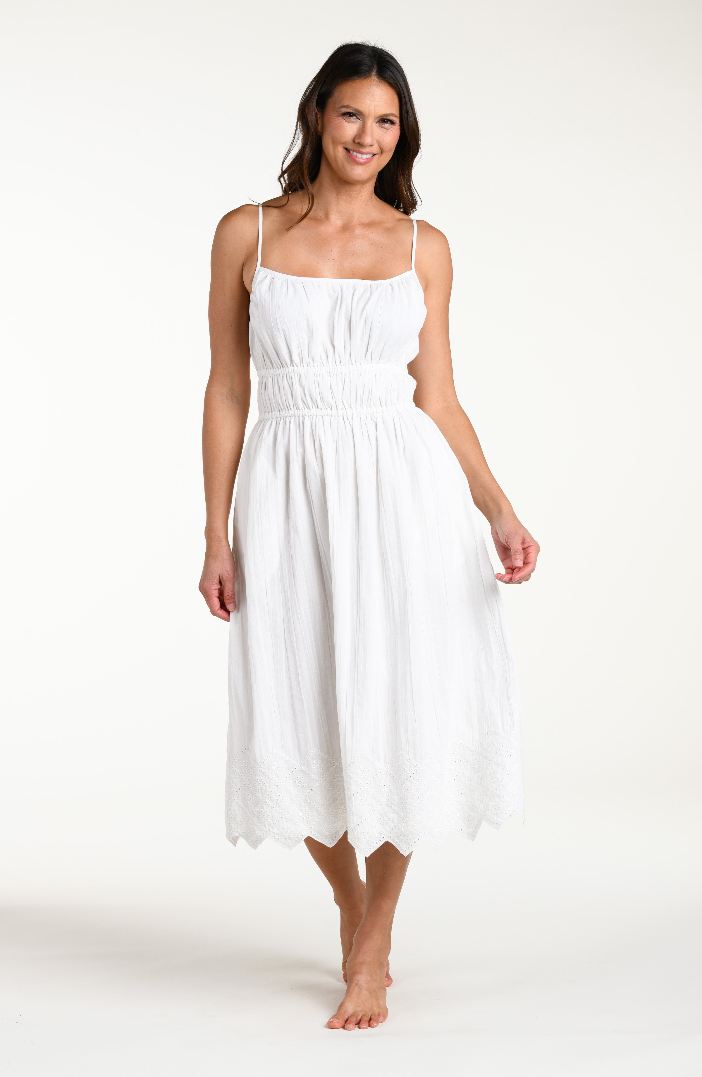 Woman wearing a white midi cover up dress against a white background