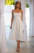 Woman wearing a white midi dress standing outdoors.