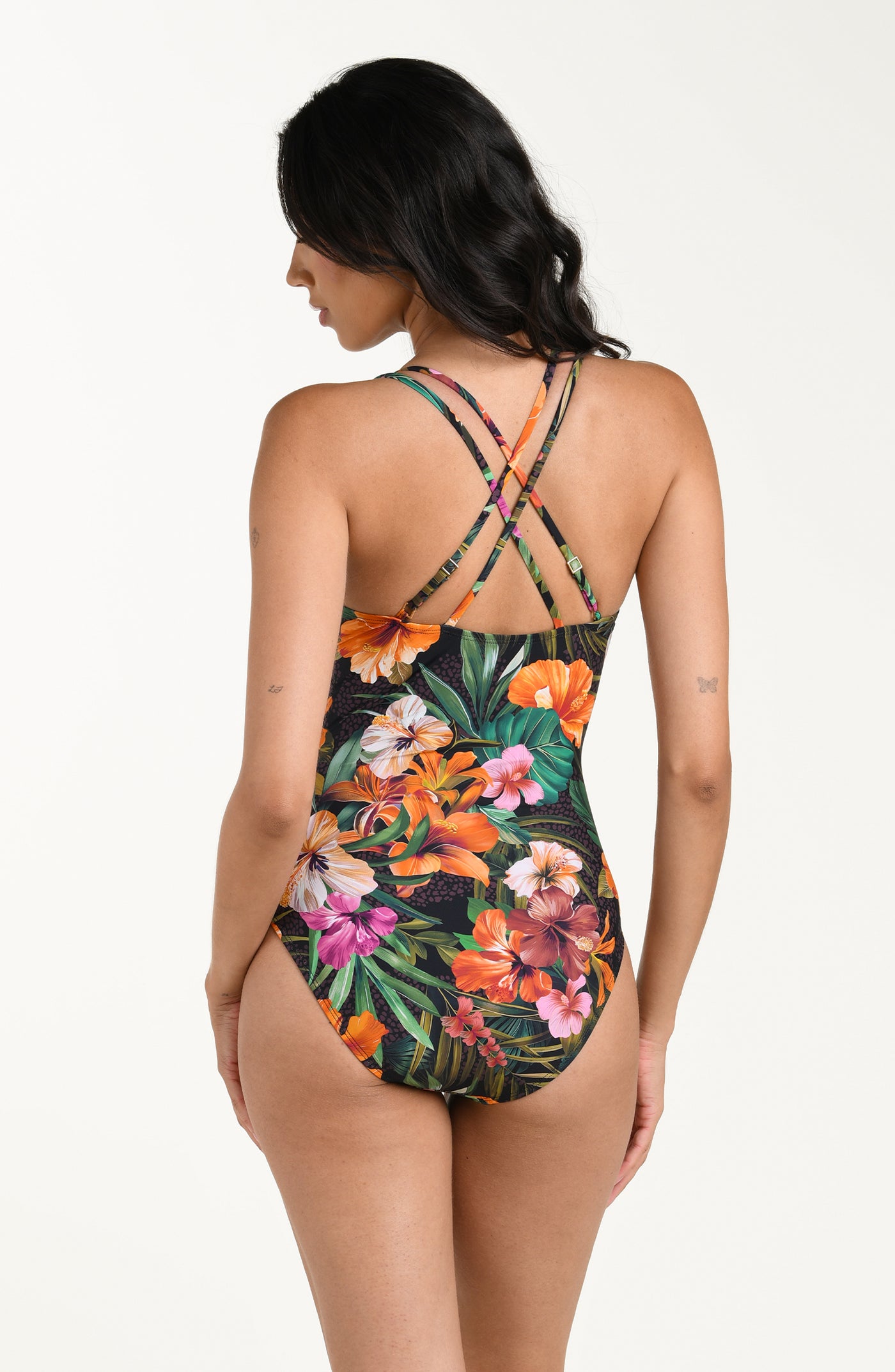
                  
                    Back image of model wearing a multicolored tropical printed one piece swimsuit featuring thin, adjustable crisscross straps, a straight back, and moderate rear coverage.
                  
                