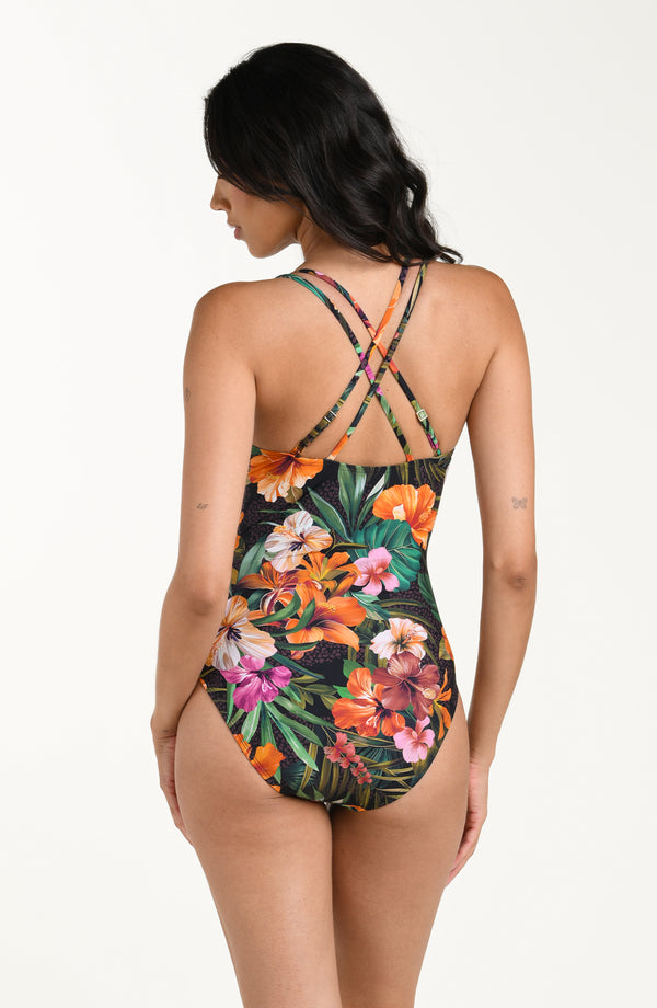 Back image of model wearing a multicolored tropical printed one piece swimsuit featuring thin, adjustable crisscross straps, a straight back, and moderate rear coverage.