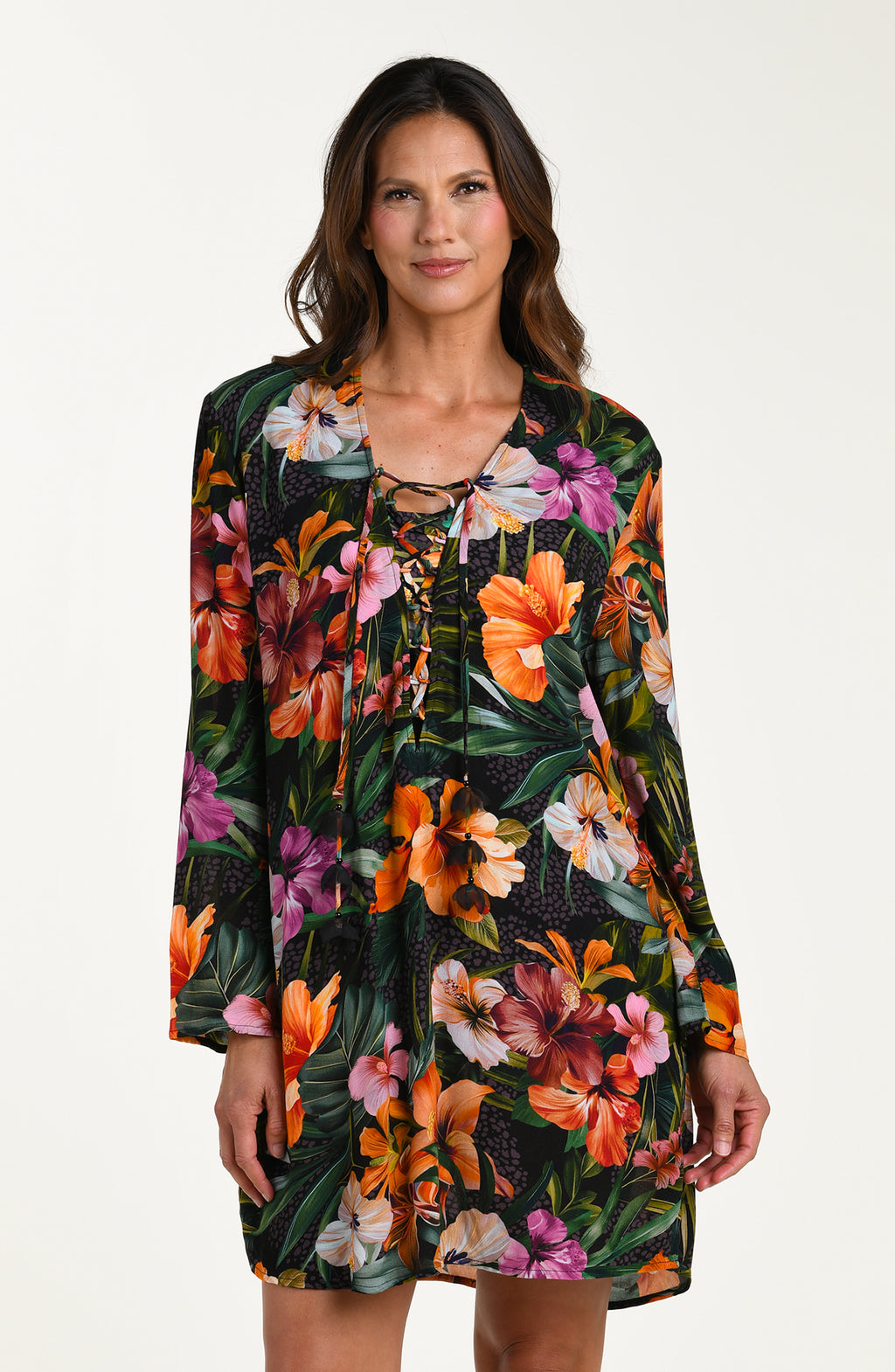 Front image of model wearing a multicolored tropical printed tunic cover-up featuring a loose, breezy fit with long sleeves and a lace-up neckline for effortless comfort and style.