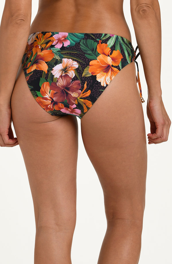 Back image of model wearing a multicolored tropical printed hipster bikini bottoms with adjustable side ties accented with gold tips and moderate rear coverage.