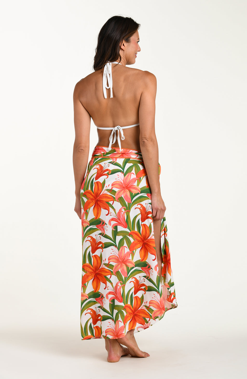 Woman wearing a matching floral swimsuit top and skirt on a white background