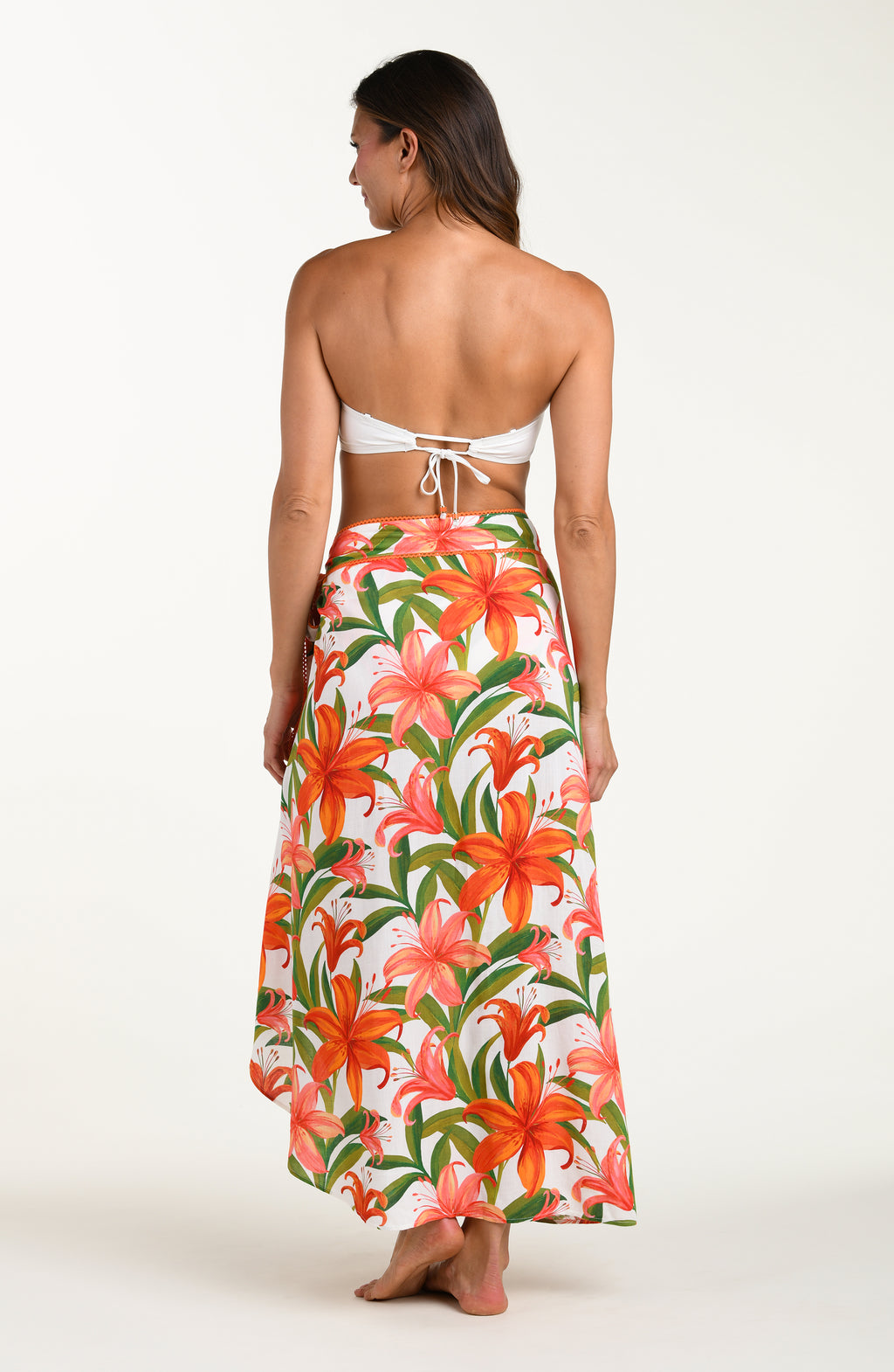 Woman wearing a matching floral swimsuit top and skirt on a white background