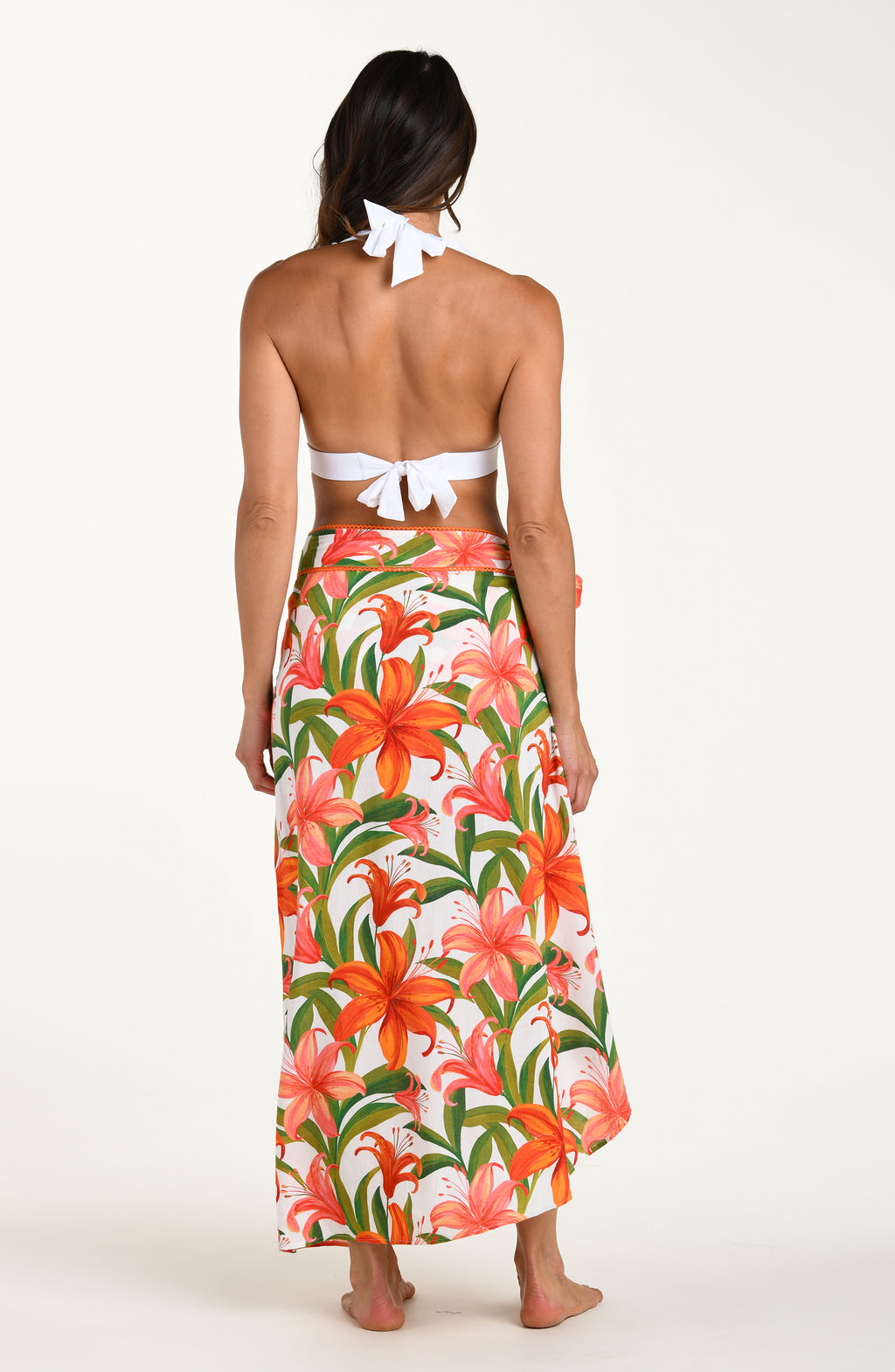 Woman wearing a matching floral swimsuit top and skirt on a white background