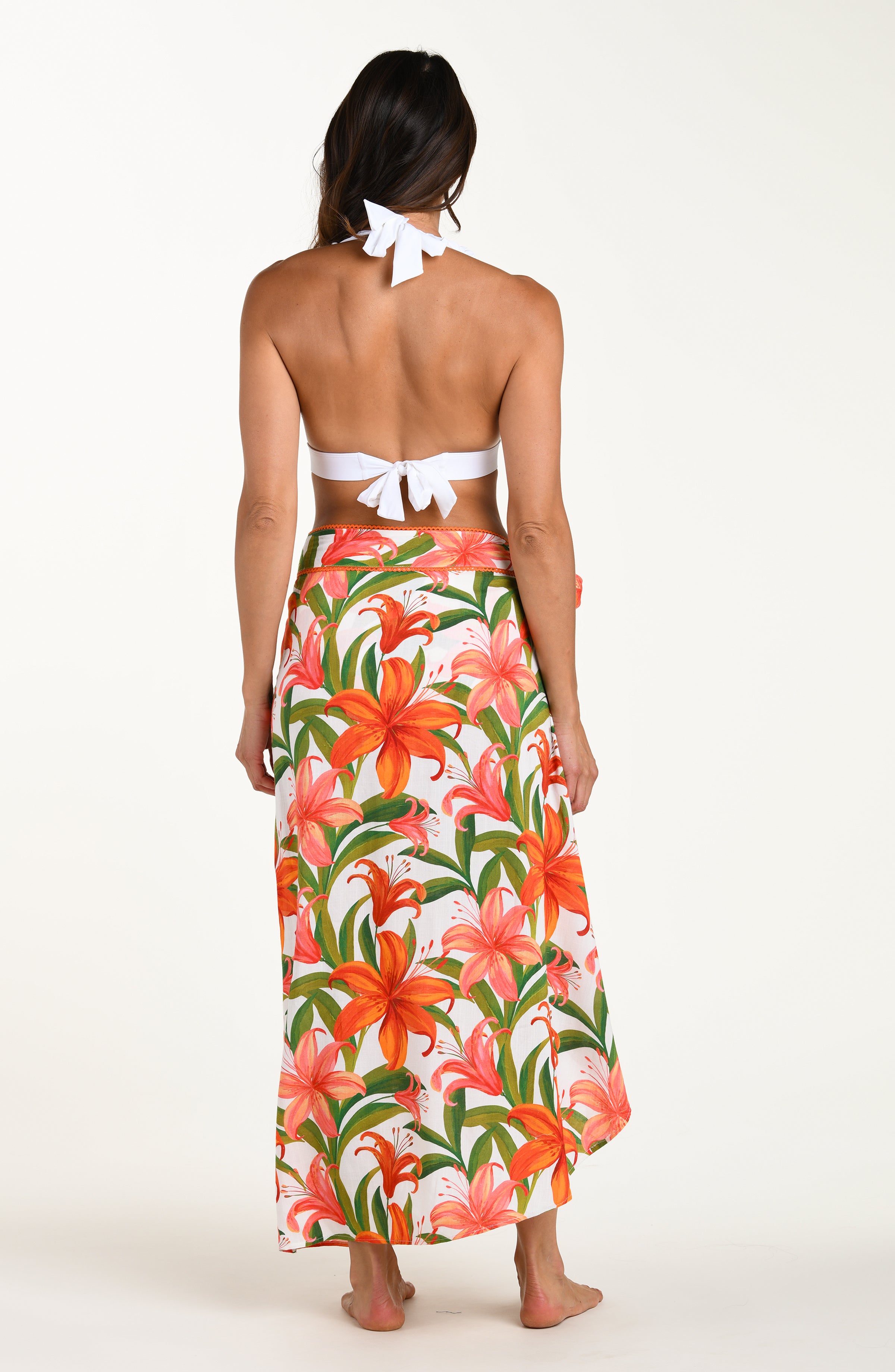 Woman wearing a matching floral swimsuit top and skirt on a white background